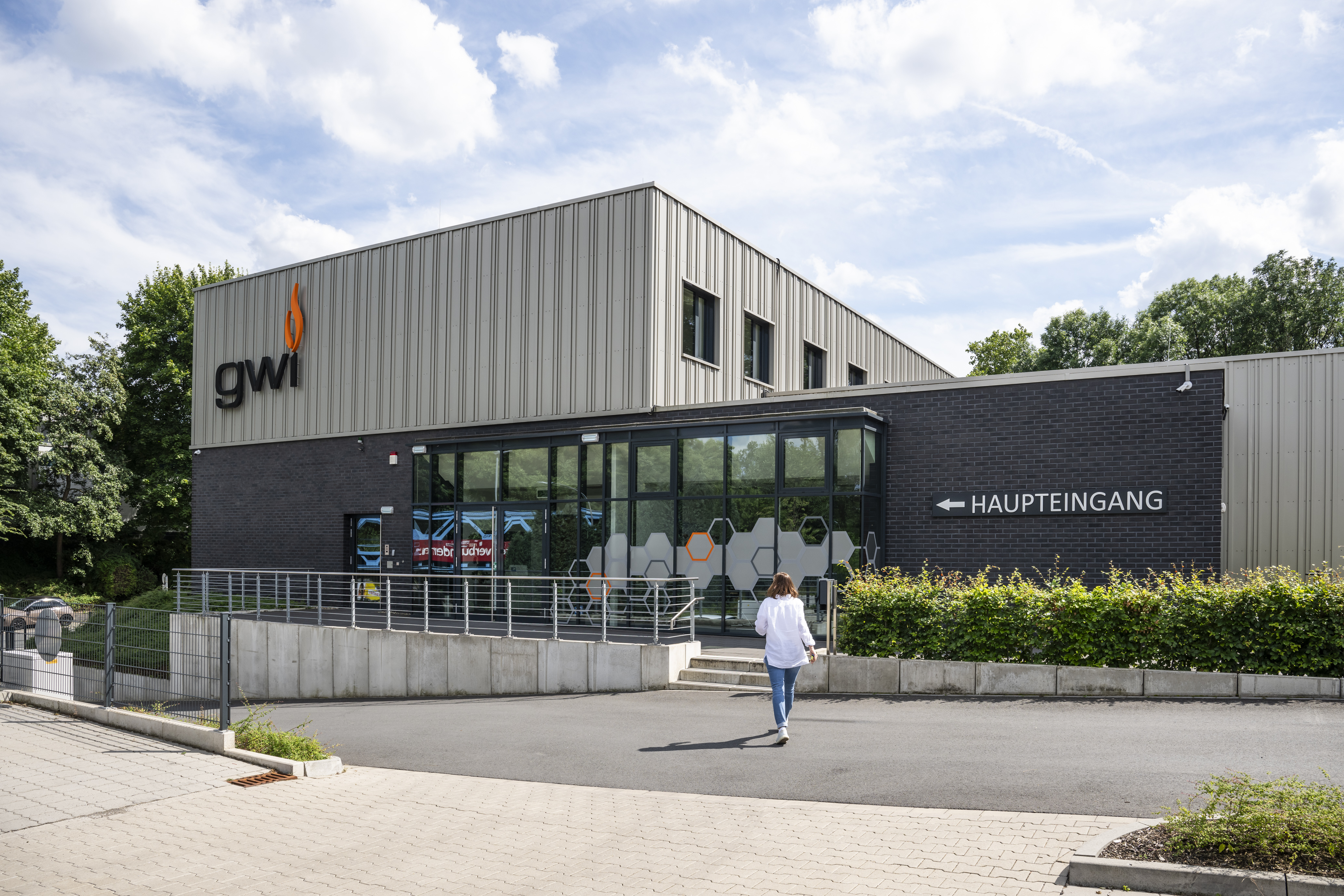 Eine Mitarbeiterin läuft auf das Schulungs- und Verwaltungsgebäude des GWI zu