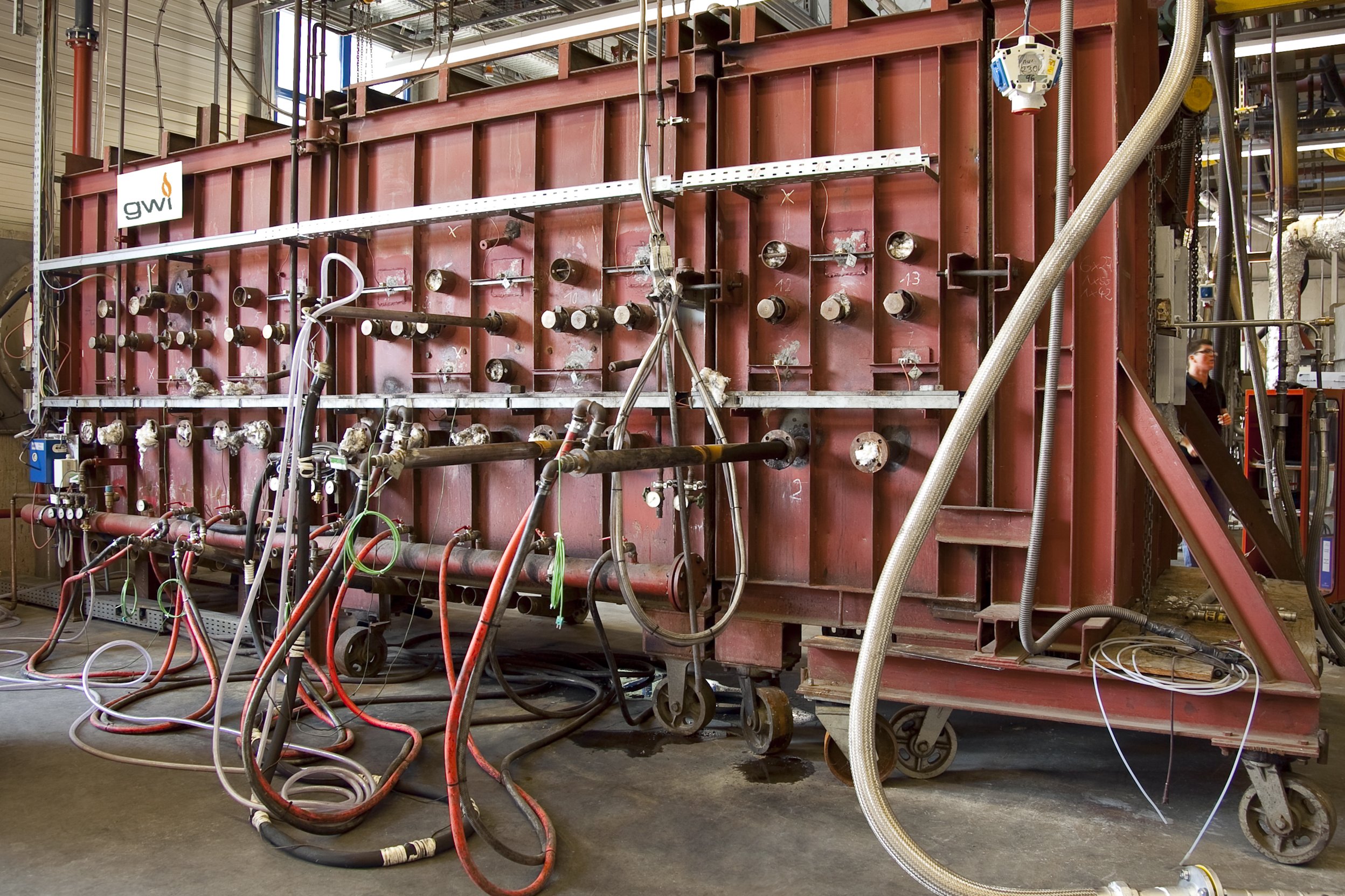 Versuchsstand des Gas- und Wärme-Instituts Essen (GWI) mit industrieller Brenneranlage, zahlreichen Messanschlüssen, Rohrleitungen und Schläuchen zur Untersuchung thermischer Prozesse. Versuchsstand des Gas- und Wärme-Instituts Essen (GWI) mit industrieller Brenneranlage, zahlreichen Messanschlüssen, Rohrleitungen und Schläuchen zur Untersuchung thermischer Prozesse.