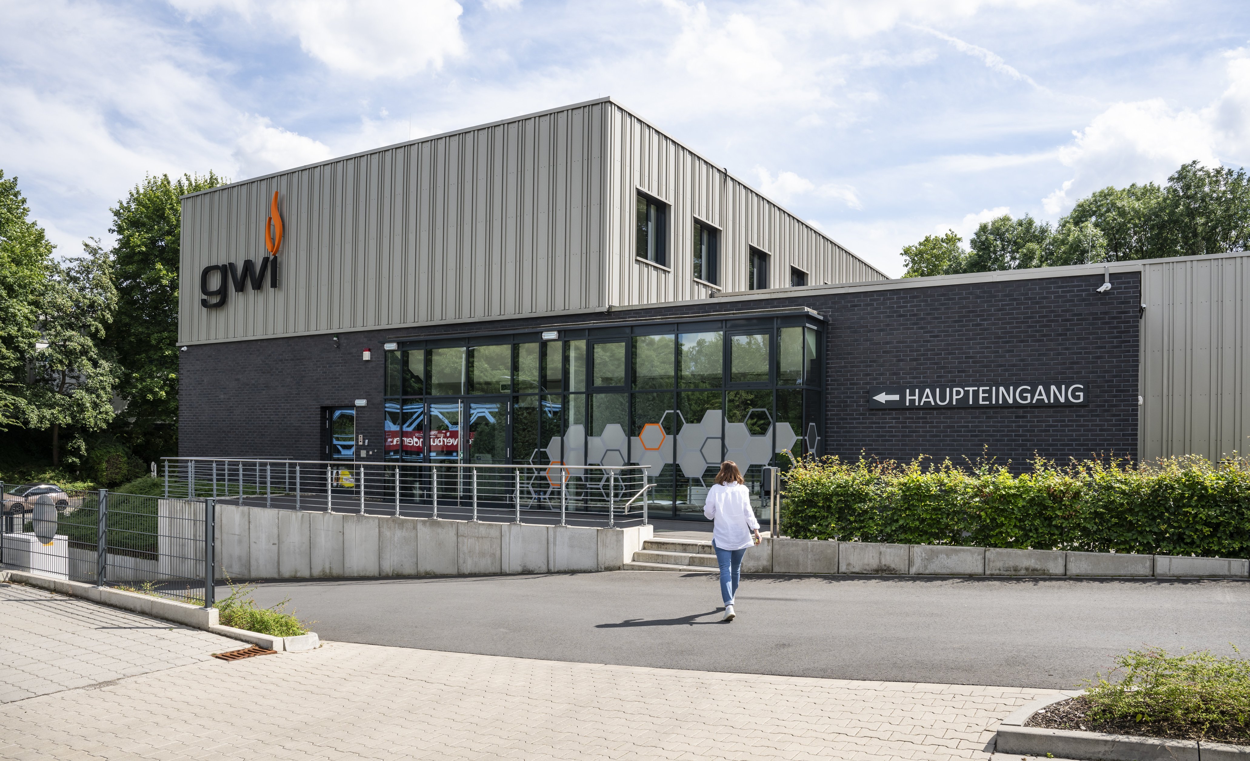Eine Mitarbeiterin geht auf den Haupteingang zu