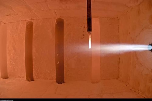 Das Bild zeigt eine Brennkammer mit laufendem Versuchsaufbau, in dem ein Ammoniakbrenner in Betrieb ist. Der Brennerstrahl tritt in die aufgeheizte Kammer ein und verdeutlicht die experimentelle Nutzung von Ammoniak (NH₃) als CO₂-freien Brennstoff. Diese Aufnahme steht für die Forschungsaktivitäten des GWI zur Dekarbonisierung energieintensiver Industrieprozesse mithilfe innovativer Brennstoffe.